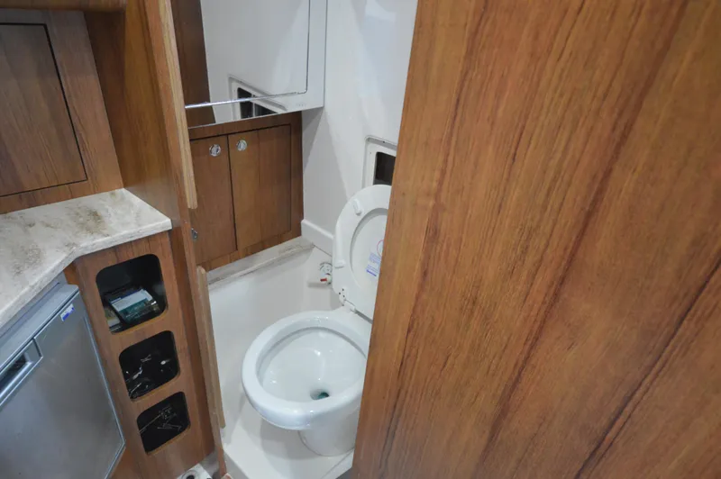 Slide: The Image of 2018 Invincible 43 Open Fisherman boat interior bathroom with wooden cabinetry and modern fixtures. - 29