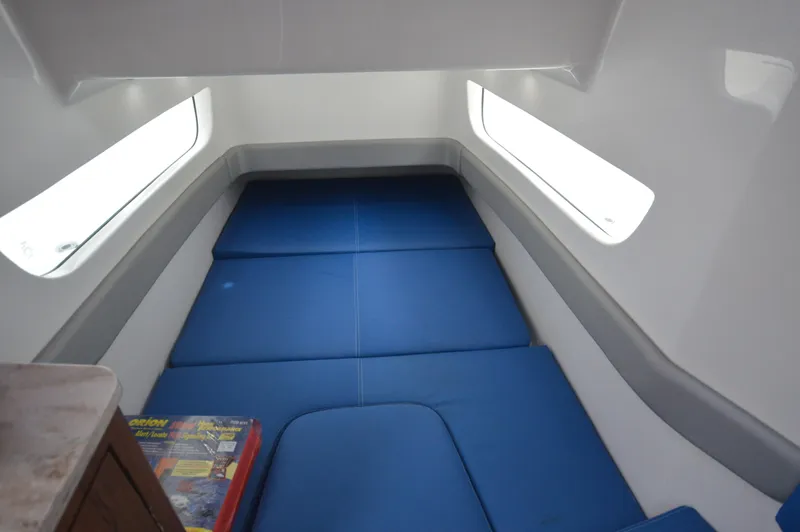 Slide: The Image of 2018 Invincible 43 Open Fisherman cabin with blue cushions and side windows. - 33