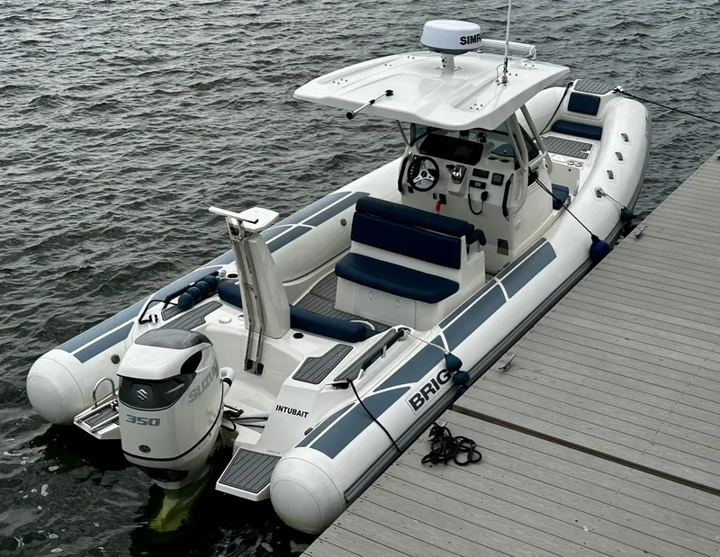 Slide: The Image of 2022 Brig Eagle 8 boat docked, featuring sleek design and powerful outboard motor. - 2