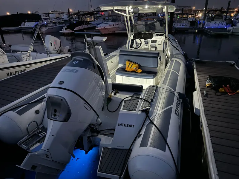 Slide: The Image of 2022 Brig Eagle 8 boat docked at night, illuminated with blue lights. - 22