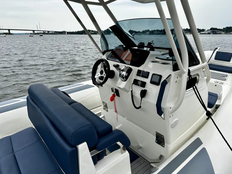 Slide: The Image of 2022 Brig Eagle 8 boat interior with steering console, blue seating, and water view. - 7