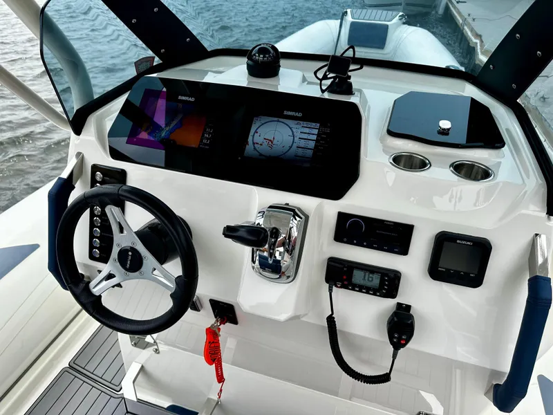 Slide: The Image of 2022 Brig Eagle 8 boat dashboard with steering wheel, navigation screens, and controls. - 9
