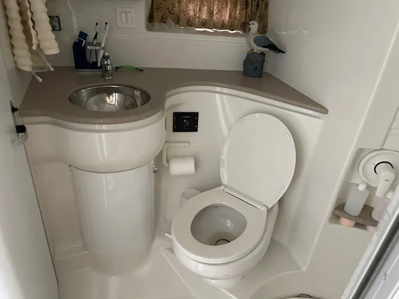 Slide: The Image of 1997 Formula 40 boat bathroom with sink, toilet, and toiletries. - 13