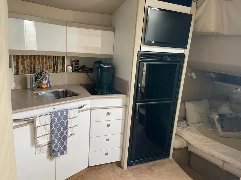 Slide: The Image of 1997 Formula 40 yacht interior kitchen with sink, stove, fridge, and TV. - 14