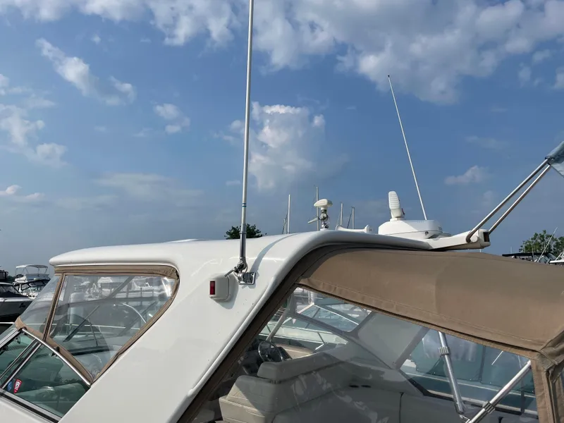 Slide: The Image of 1997 Formula 40 boat with beige canopy and antenna, docked under a blue sky. - 4
