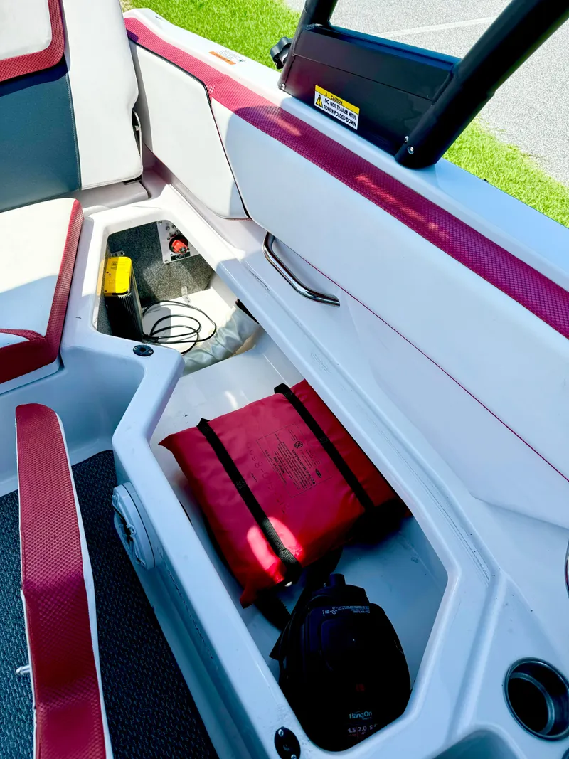 Slide: The Image of 2015 Scarab 215 HO Impulse boat interior storage with safety equipment. - 11