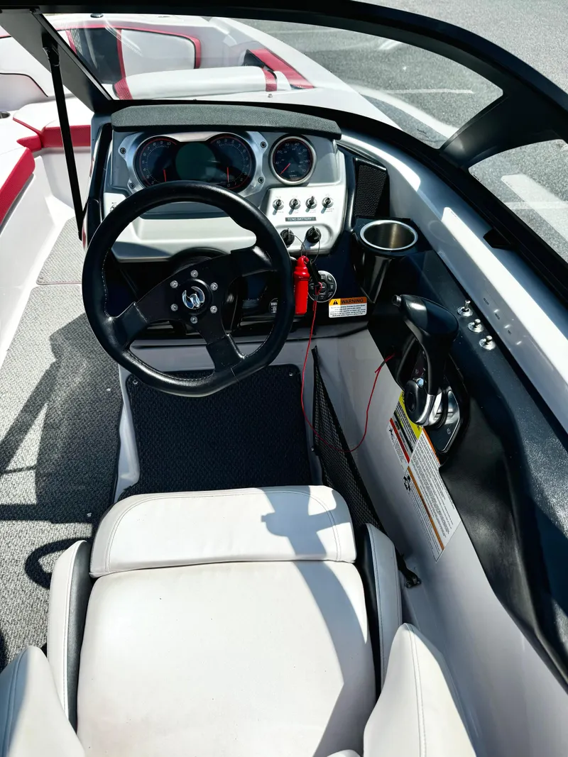 Slide: The Image of 2015 Scarab 215 HO Impulse boat cockpit with steering wheel and dashboard controls. - 13