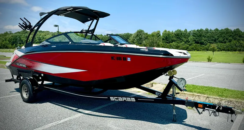 Slide: The Image of 2015 Scarab 215 HO Impulse boat on trailer in parking lot. - 16