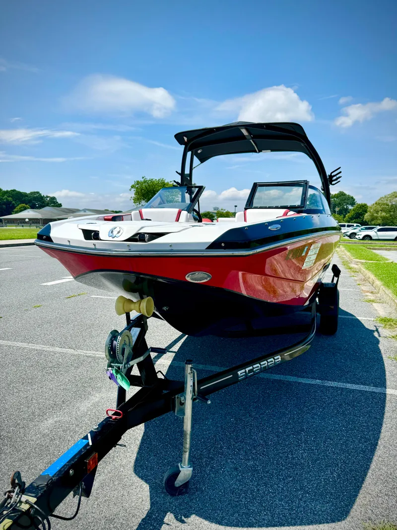 Slide: The Image of 2015 Scarab 215 HO Impulse boat on trailer, parked outdoors. - 19