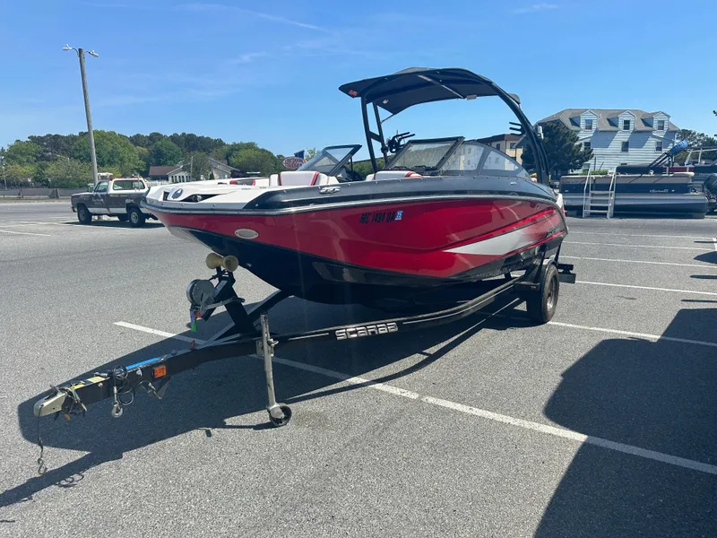 Slide: The Image of 2015 Scarab 215 HO Impulse boat in a parking lot. - 2