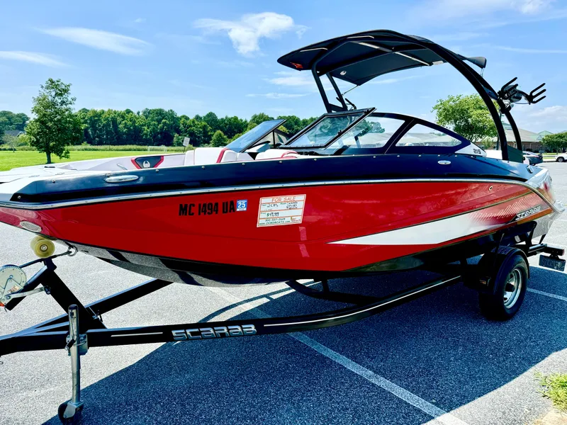 Slide: The Image of 2015 Scarab 215 HO Impulse boat on trailer in sunny parking lot. - 20
