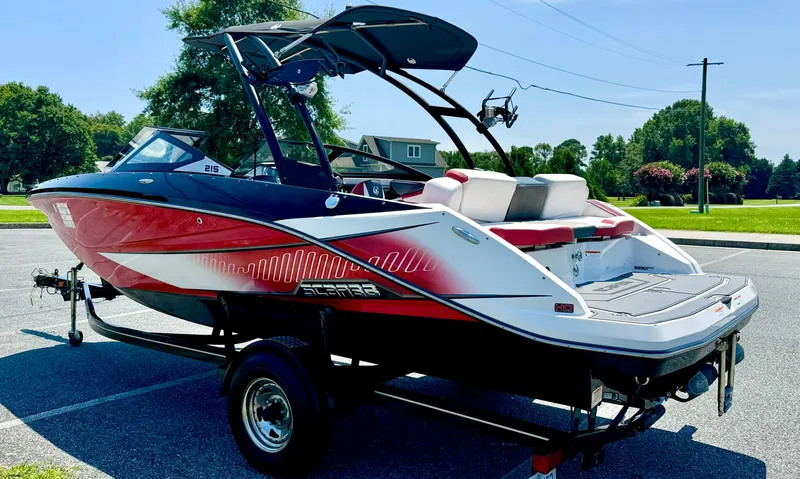 Slide: The Image of 2015 Scarab 215 HO Impulse boat on trailer, red and white design, parked outdoors. - 22