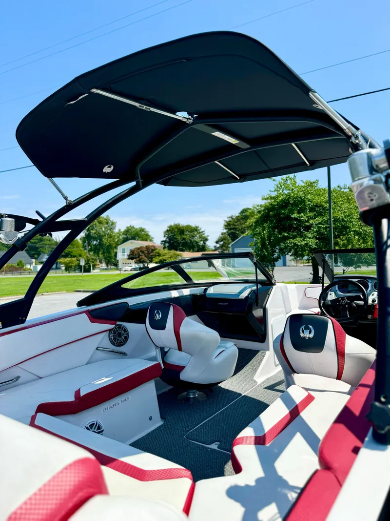Slide: The Image of 2015 Scarab 215 HO Impulse boat interior with red and white seating, black canopy. - 24
