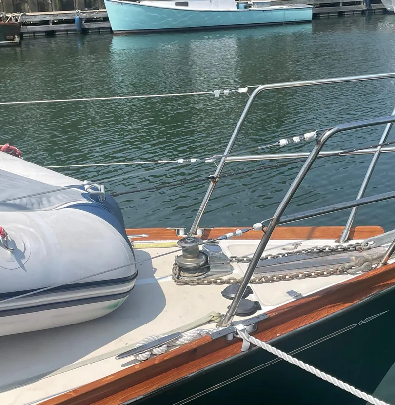 Slide: The Image of 2001 Tartan 4100 yacht bow with dinghy, docked in calm marina waters. - 12