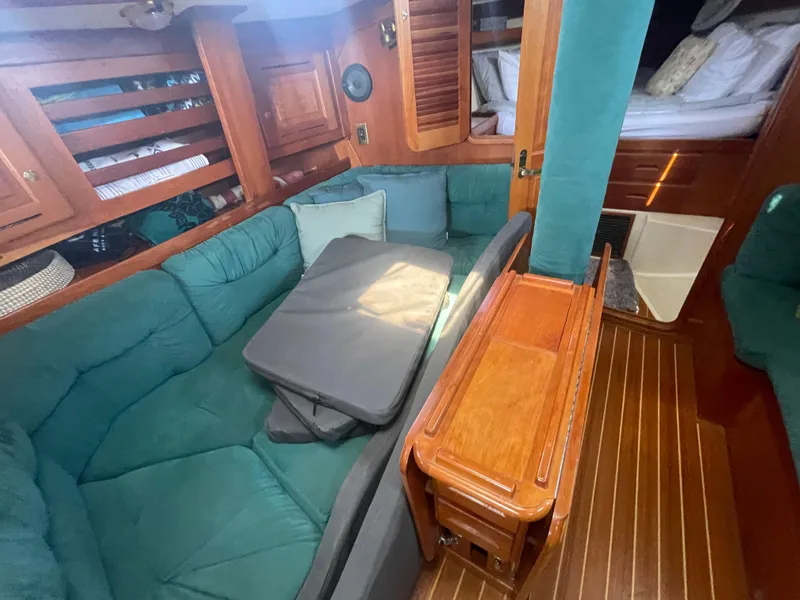Slide: The Image of Interior of 2001 Tartan 4100 sailboat with green seating and wooden accents. - 24