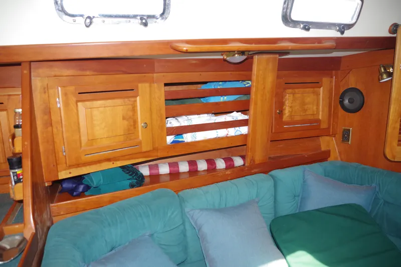 Slide: The Image of Interior of 2001 Tartan 4100 sailboat with wooden cabinets and teal cushions. - 25