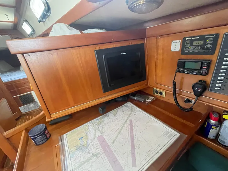Slide: The Image of Navigation station on 2001 Tartan 4100 sailboat with chart, radio, and equipment. - 26