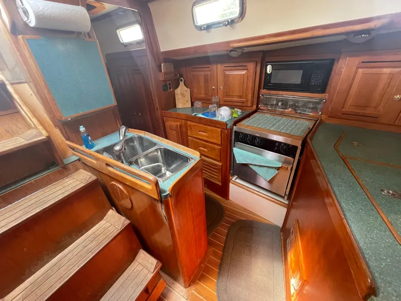 Slide: The Image of Interior of 2001 Tartan 4100 sailboat kitchen with wood cabinetry and modern appliances. - 30