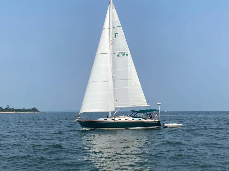 Slide: The Image of Sailboat Tartan 4100 (2001) cruising on a calm lake under a partly cloudy sky. - 41