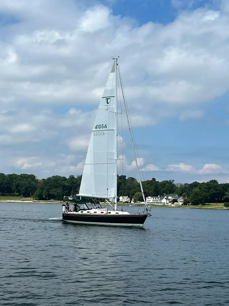 Slide: The Image of Sailboat Tartan 4100 (2001) cruising on a calm lake under a partly cloudy sky. - 5