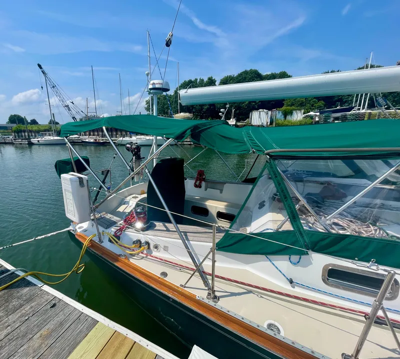 Slide: The Image of Tartan 4100 sailboat docked, featuring green canopy, 2001 model. - 7
