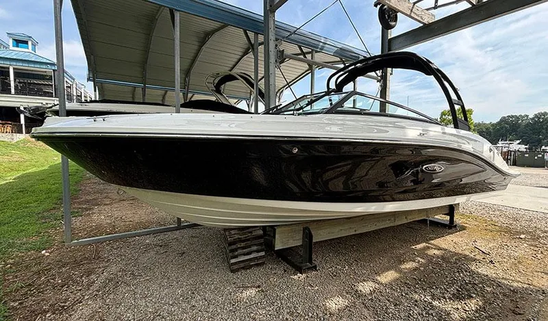 The Image of 2025 Sea Ray SPX 230 Outboard boat on a dry dock under a canopy. - 0