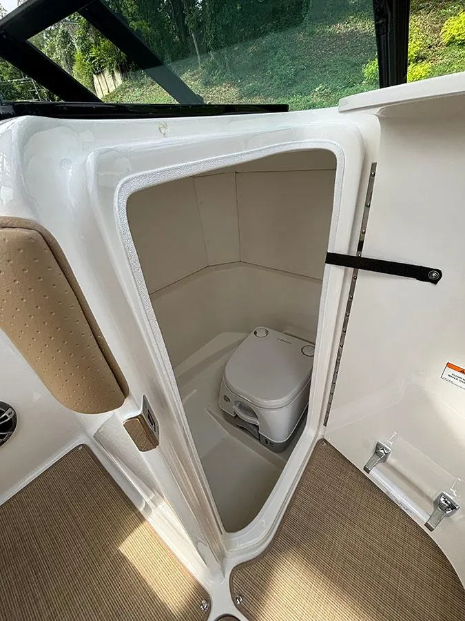 Slide: The Image of 2025 Sea Ray SPX 230 Outboard boat interior with compact toilet. - 7