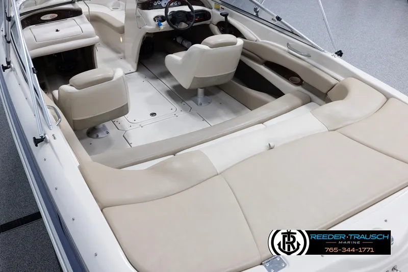 Slide: The Image of 2002 Larson LXI 210 boat interior with beige seating and steering console. - 10