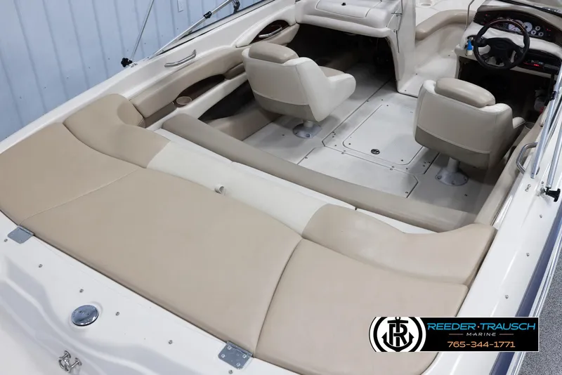 Slide: The Image of 2002 Larson LXI 210 boat interior with beige seating and steering console. - 11