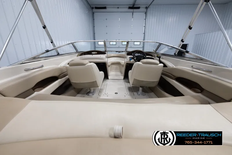 Slide: The Image of Interior of a 2002 Larson LXI 210 boat with beige seating in a garage. - 12