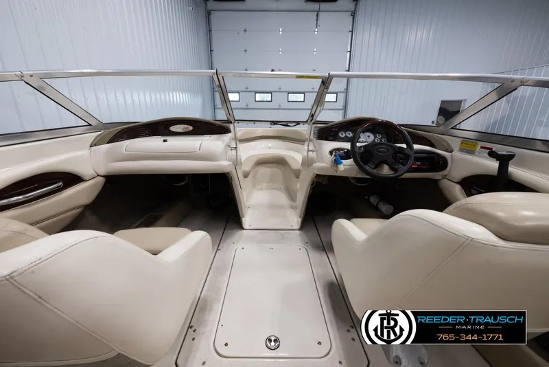 Slide: The Image of 2002 Larson LXI 210 boat interior with steering wheel and seating. - 13