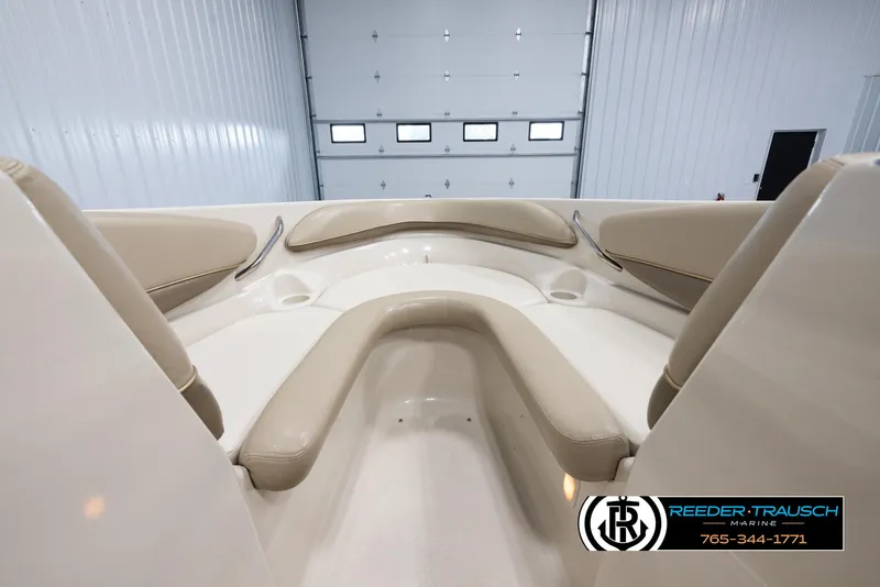 Slide: The Image of 2002 Larson LXI 210 boat interior with beige seating in a garage. - 14