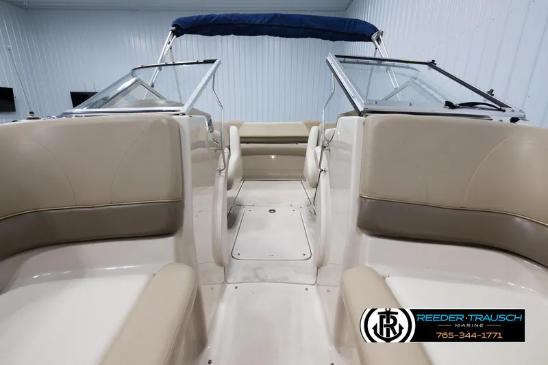 Slide: The Image of 2002 Larson LXI 210 boat interior with beige seating and blue canopy. - 15