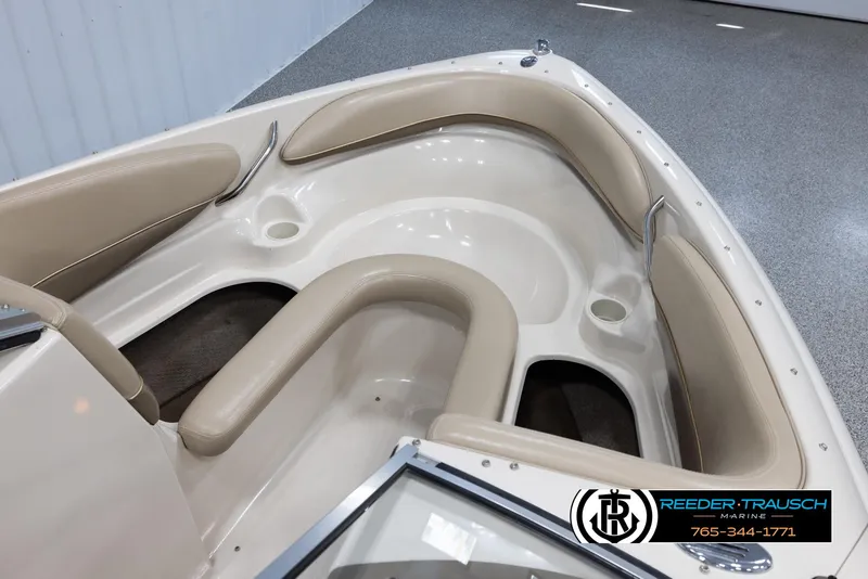 Slide: The Image of 2002 Larson LXI 210 boat interior with beige seating and Reeder-Trausch Marine logo. - 19
