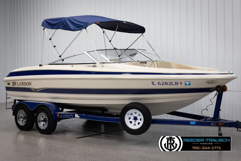 Slide: The Image of 2002 Larson LXI 210 boat on trailer with blue canopy. - 2