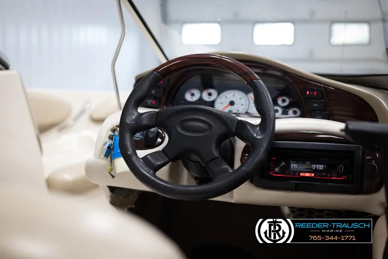 Slide: The Image of 2002 Larson LXI 210 boat dashboard with steering wheel and instrument panel. - 22