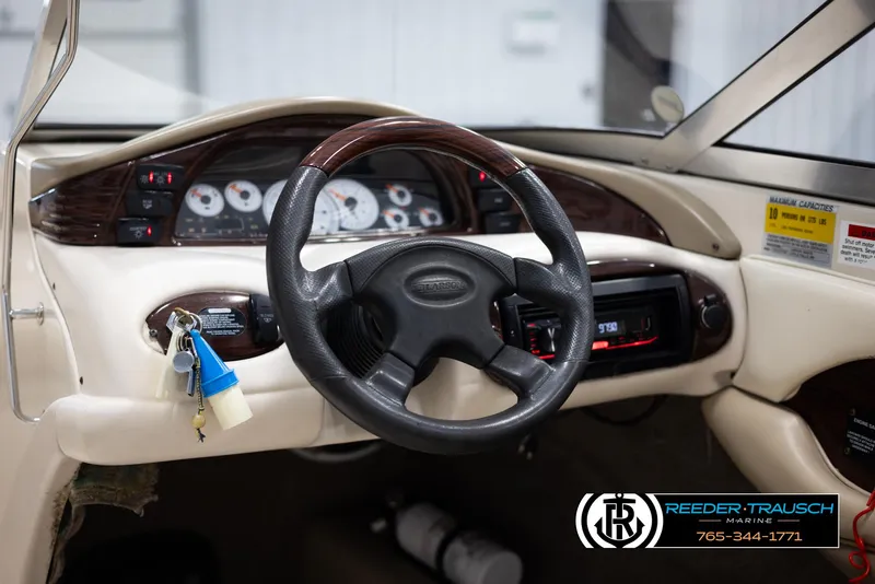 Slide: The Image of 2002 Larson LXI 210 boat dashboard with steering wheel and instrument panel. - 23