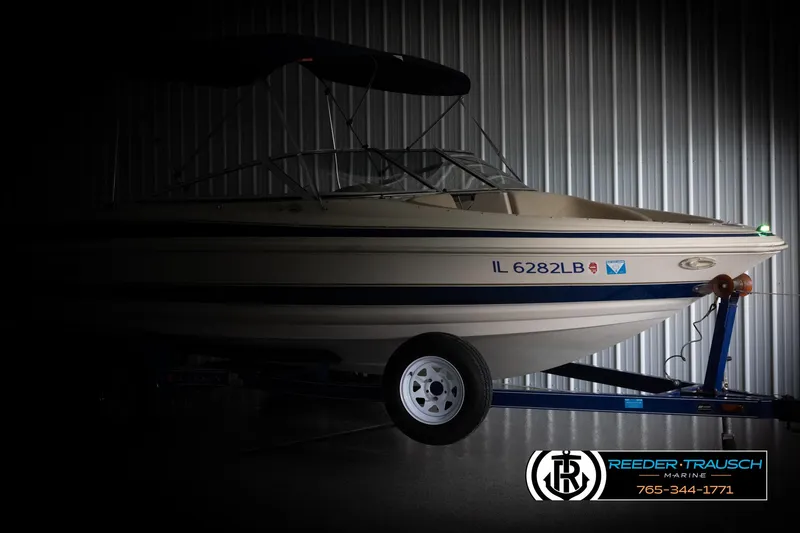 Slide: The Image of 2002 Larson LXI 210 boat on trailer in storage facility. - 3