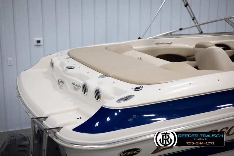 Slide: The Image of 2002 Larson LXI 210 boat with beige seating and blue accents in a showroom. - 37
