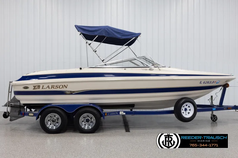 Slide: The Image of 2002 Larson LXI 210 boat with blue and white design on trailer. - 4