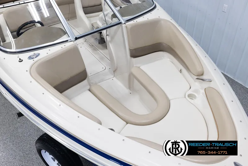 Slide: The Image of 2002 Larson LXI 210 boat interior with beige seating and white accents. - 8