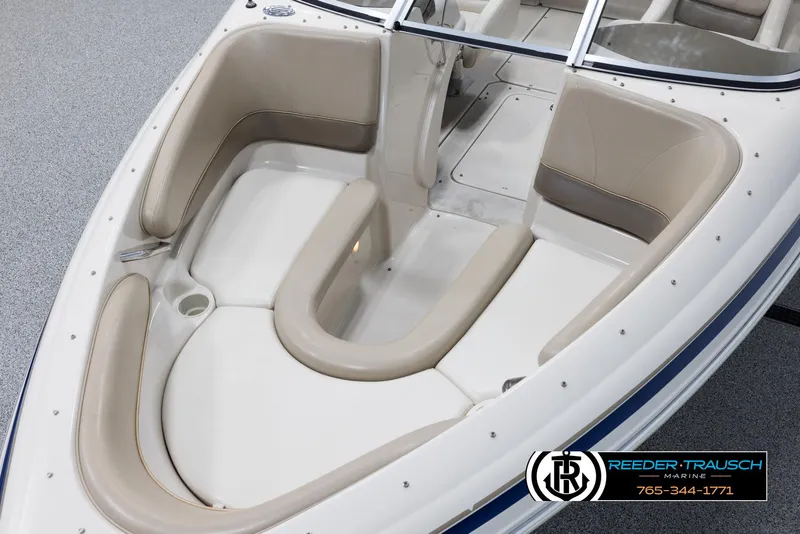 Slide: The Image of 2002 Larson LXI 210 boat with beige seating and open bow area. - 9