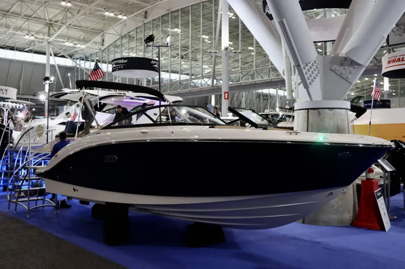 Slide: The Image of 2025 Sea Ray 210SPX boat displayed at an indoor boat show. - 13