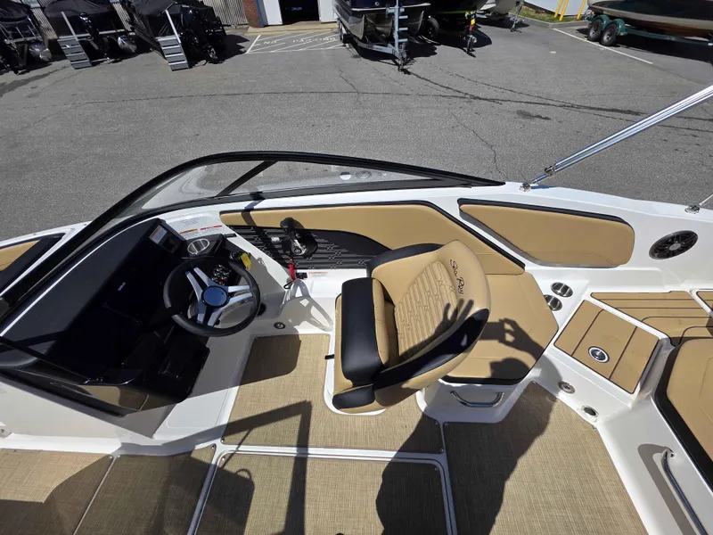 Slide: The Image of 2025 Sea Ray 210SPX boat interior with tan seating and steering wheel. - 8