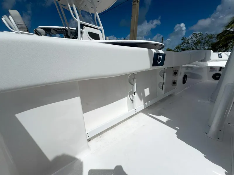 Slide: The Image of 2025 Sea Fox 248 Commander boat deck with storage compartments under a clear blue sky. - 22