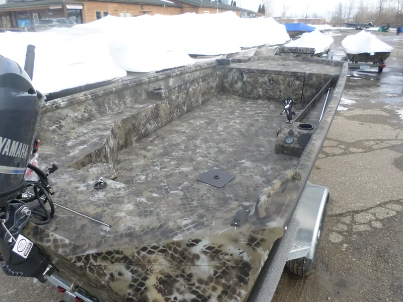 Slide: The Image of 2025 Excel 1864 SWSB boat with camouflage design, parked on a trailer. - 3