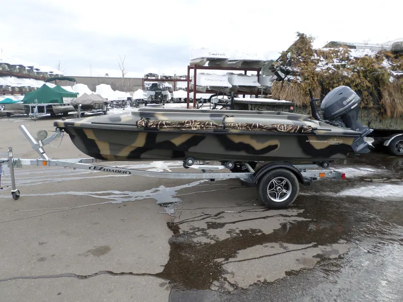 Slide: The Image of 2024 Bankes 14' Dominator boat on EZ Loader trailer in outdoor lot. - 1