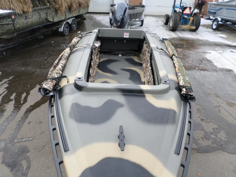 Slide: The Image of 2024 Bankes 14' Dominator boat with camouflage design, parked on a wet surface. - 3