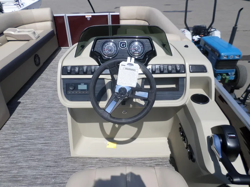 Slide: The Image of 2024 Godfrey Sweetwater 2286SB Tri pontoon boat helm with steering wheel and control panel. - 6