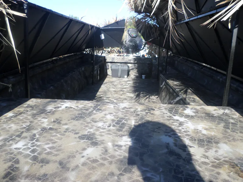 Slide: The Image of 2024 Excel 1860 SWV4 OFP boat interior with camouflage pattern and covered seating. - 2